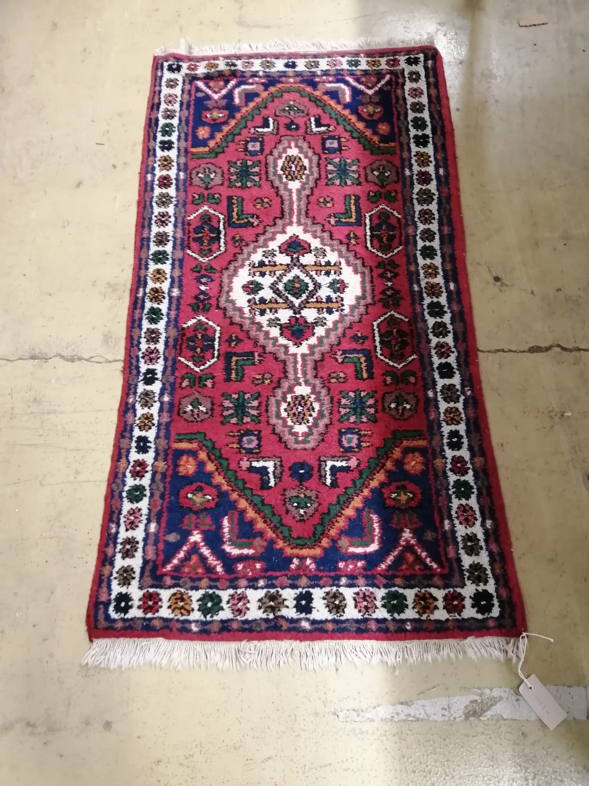 A Caucasian style red ground rug, 130cm x 68cm